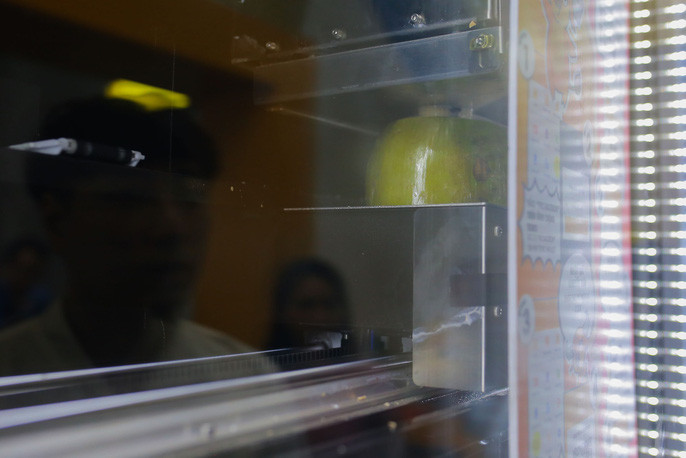 Không còn cảnh phải dùng dao để chặt dừa, những trái dừa sẽ được di chuyển lên phía trên và sẽ được "chặt" tự động ngay trên máy.