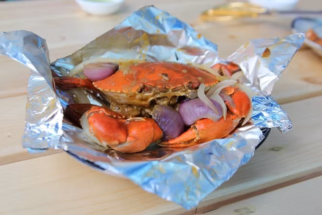 Cua nướng giấy bạc, gọi là nướng song phần giấy bạc bên ngoài giữ lại nước nên thịt cua tươi ngọt, đậm đà chứ không khô cứng như cách nướng thông thường. Ảnh: An Huỳnh.