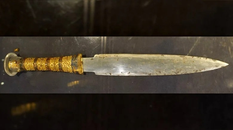Con dao găm được chạm khắc tinh xảo và trang trí pha lê. Vũ khí này được chế tạo từ liệu kim loại đồng nhất không han gỉ, lưỡi dao sắc bén dù đã hàng ngàn tuổi và phần chuôi đúc bằng vàng. Ảnh: Wikimedia Commons/Olaf Tausch.