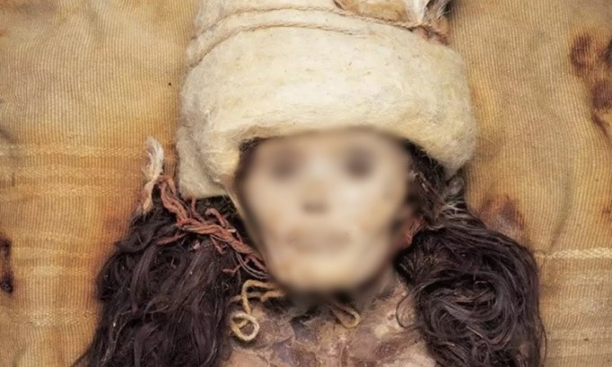 Khóe miệng của "công chúa Tân Cương" dường như đang nở nụ cười. Mỹ nhân này đội mũ màu trắng trên đầu, đeo một vòng cổ bằng dây màu đỏ có đính cườm, tay đeo chiếc vòng hạt ngọc hình ống. Ảnh: Vice.