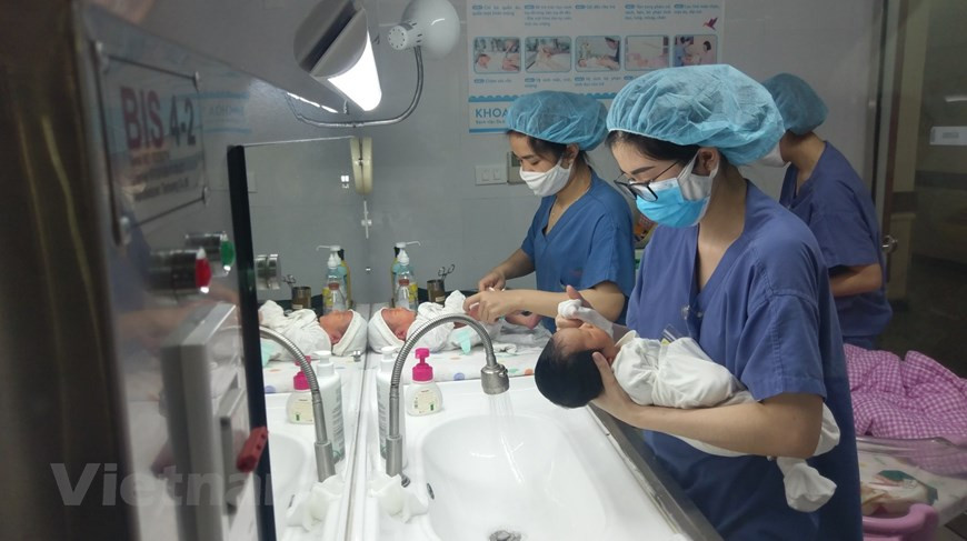 Nhân viên sản khoa tắm cho trẻ mỗi sáng. (Ảnh: PV/Vietnam+)