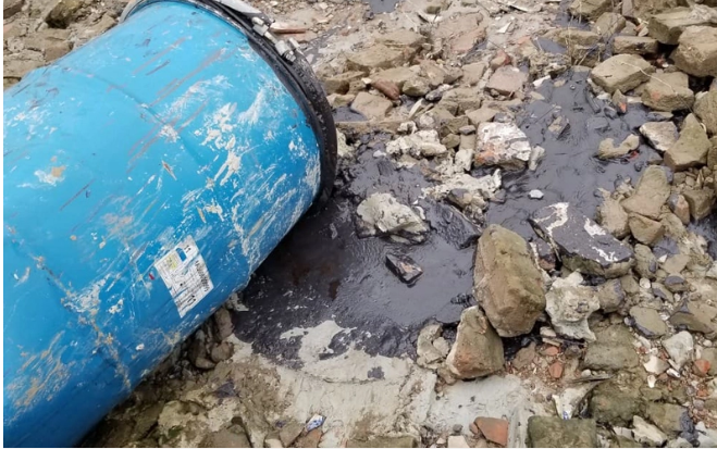 Hóa chất lạ có màu đen xì chảy rò rỉ từ bên trong những chiếc thùng phuy ra môi trường rồi ngấm xuống dòng chảy của sông Hồng.