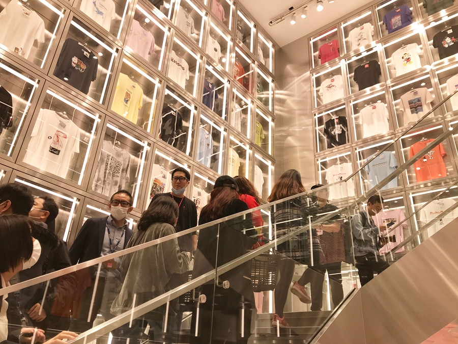 Khách hàng bắt đầu chen chân mua sắm bên trong cửa hàng Uniqlo. Khu vực 3 bức tường áo phông UT bao quanh cầu thang lên tầng 2 khá nổi bật.