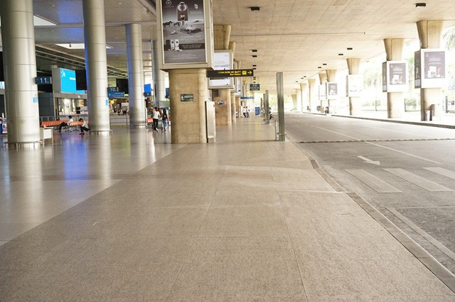 Sảnh đến của ga quốc tế vắng hoe, chỉ có 2 người đi lại cùng nhân viên an ninh.