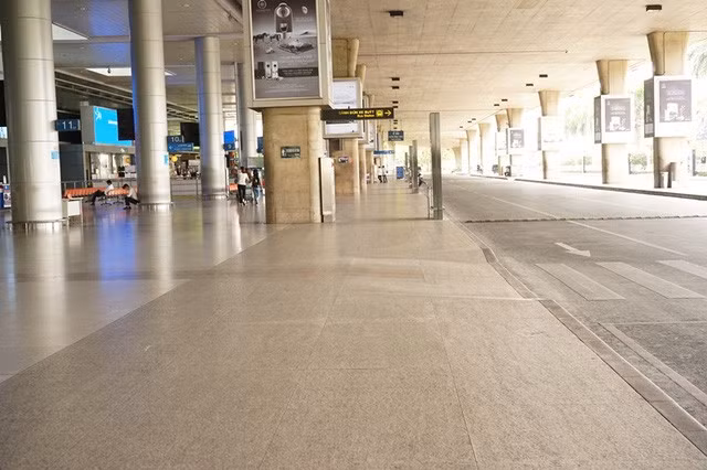 Sảnh đến của ga quốc tế vắng hoe, chỉ có 2 người đi lại cùng nhân viên an ninh.