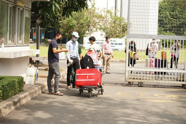 Trong ảnh là nhân viên kiểm soát sân bay phun khử khuẩn hành lý của hành khách để đưa cho người nhà mang về nhà.