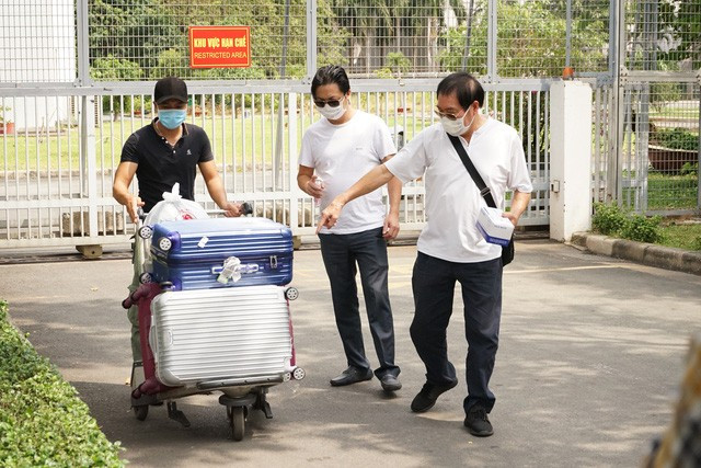 Người nhà khử khuẩn và nhận hành lý của hành khách.