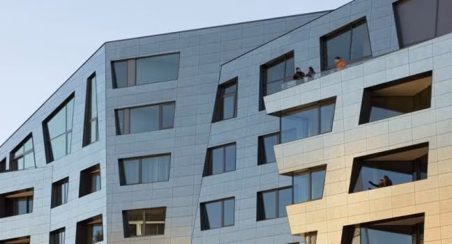 Trong đó, các mặt của tòa chung cư này ấn tượng với các kiểu kiến trúc vô cùng độc lạ. Nó bao gồm các khối ô hình học không cố định, muôn màu muôn vẻ, xếp liền góc cạnh với nhau lồi lõm nhìn từ xa chả khác gì tòa nhà méo xẹo hoặc cảm giác sắp bị đổ. 