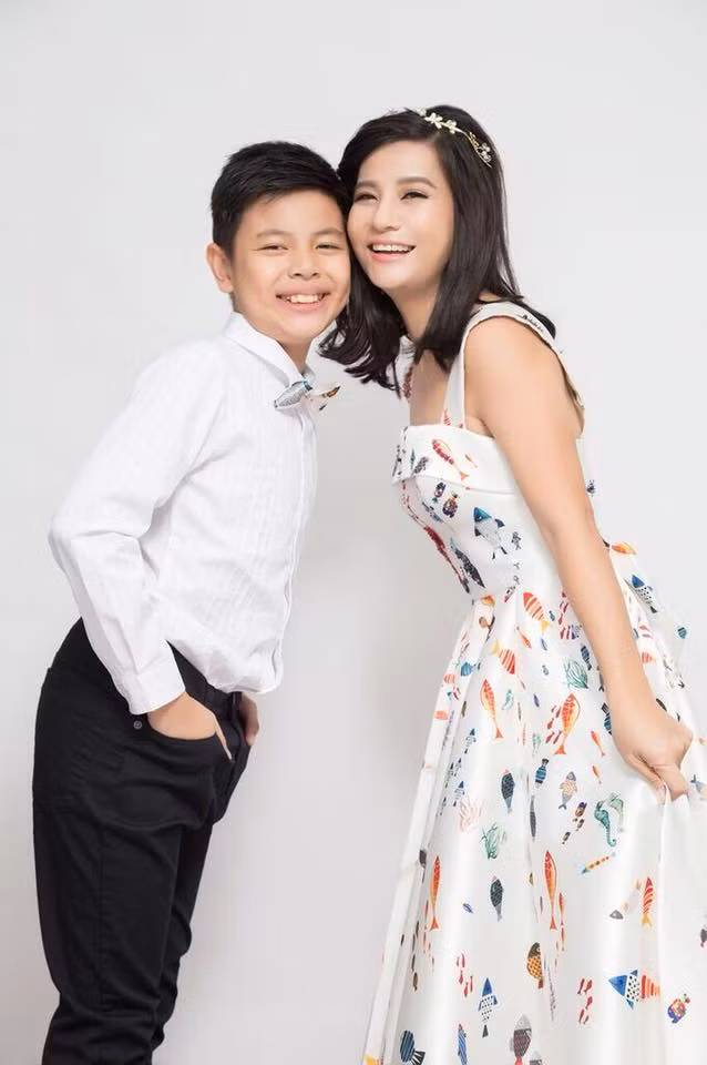 Cát Phượng mặc đầm xòe nhí nhảnh chụp ảnh cùng con trai.