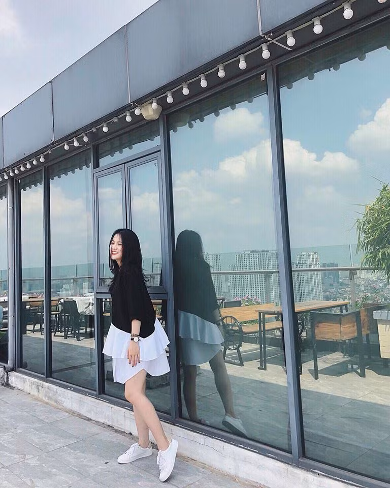 Hoàng Anh diện váy đen cách điệu ở phần chân váy trắng, phối với giày thể thao năng động, trẻ trung.