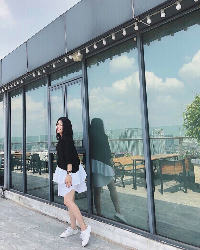 Hoàng Anh diện váy đen cách điệu ở phần chân váy trắng, phối với giày thể thao năng động, trẻ trung.