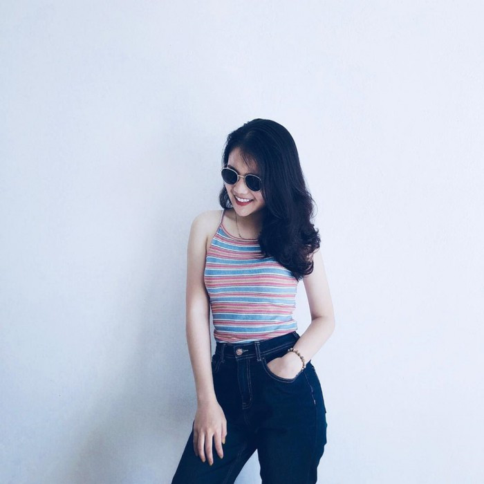 Áo phông hai dây và quần jean cạp cao rất ngầu. Set đồ giúp cô khoe được những lợi thế cơ thể như eo thon và vòng ba căng tròn.