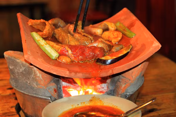 Bò nướng ngói: Đến với ẩm thực Bình Dương, bạn không nên bỏ qua món ăn đặc biệt này. Bò sau khi sơ chế, tẩm ướp gia vị sẽ được nướng trên ngói. Lớp ngói không chỉ giúp thịt bò không quá cháy, cản lửa để thịt bò đủ thời gian chín ở bên trong, mà còn dậy lên mùi thơm của thịt bò khi nướng. Ảnh: Dulichtoday.