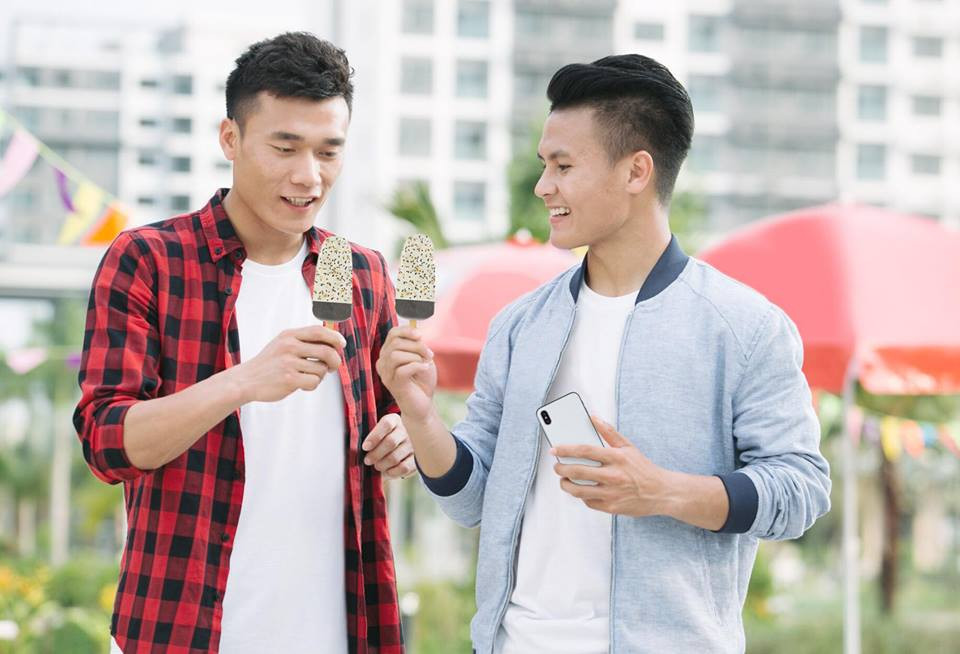 Quang Hải diện áo phông trắng phối với áo khoác bên ngoài cực ngầu khi chụp ảnh ăn kem cùng thủ môn Bùi Tiến Dũng. Ảnh: FBNV.