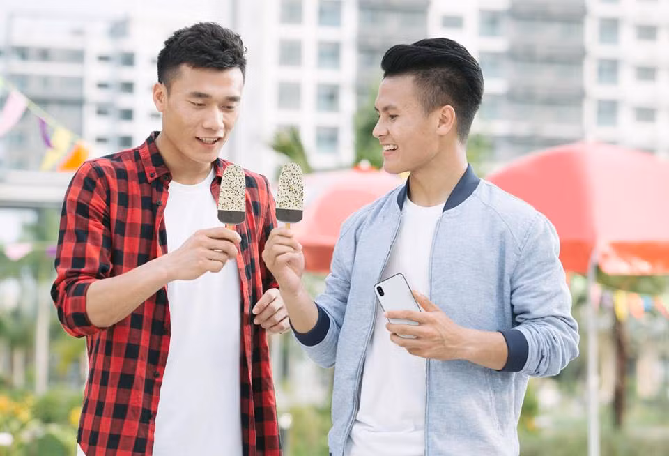 Quang Hải diện áo phông trắng phối với áo khoác bên ngoài cực ngầu khi chụp ảnh ăn kem cùng thủ môn Bùi Tiến Dũng. Ảnh: FBNV.