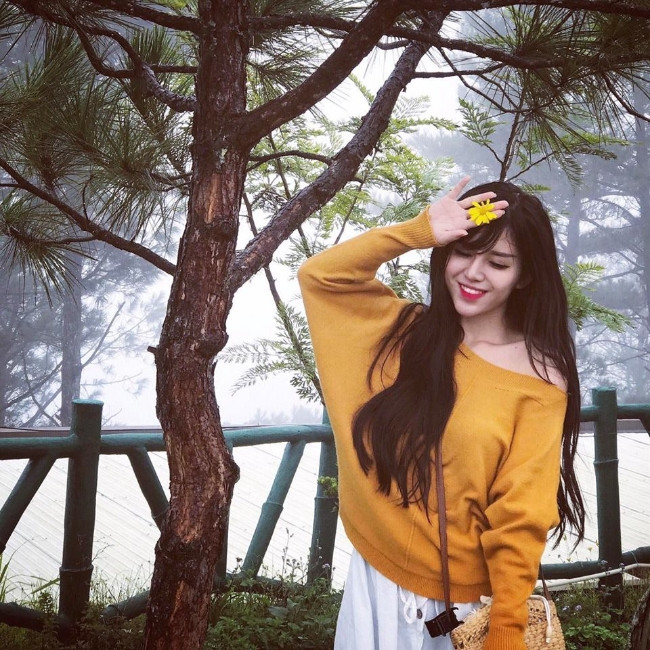 Áo len vàng phối với váy trắng giúp cô nàng nổi bật và nữ tính.