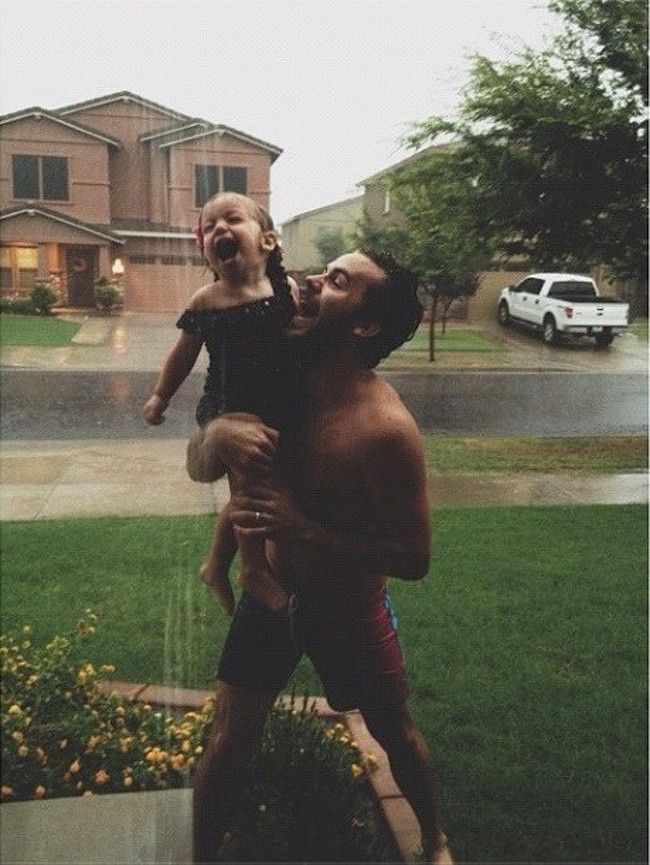 Hai bố con cùng tắm mưa một cách đầy phấn khích.