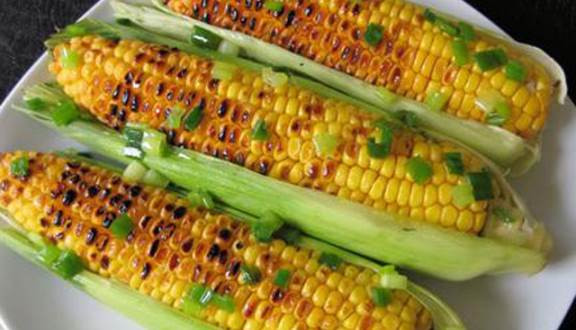 Bắp nướng mỡ hành: Từng trái bắp vàng mọng trở qua trở lại trên bếp than hồng tuy có lâu chín thật, nhưng thật đáng để bạn "bõ công" chờ đợi. Ảnh: Foody.