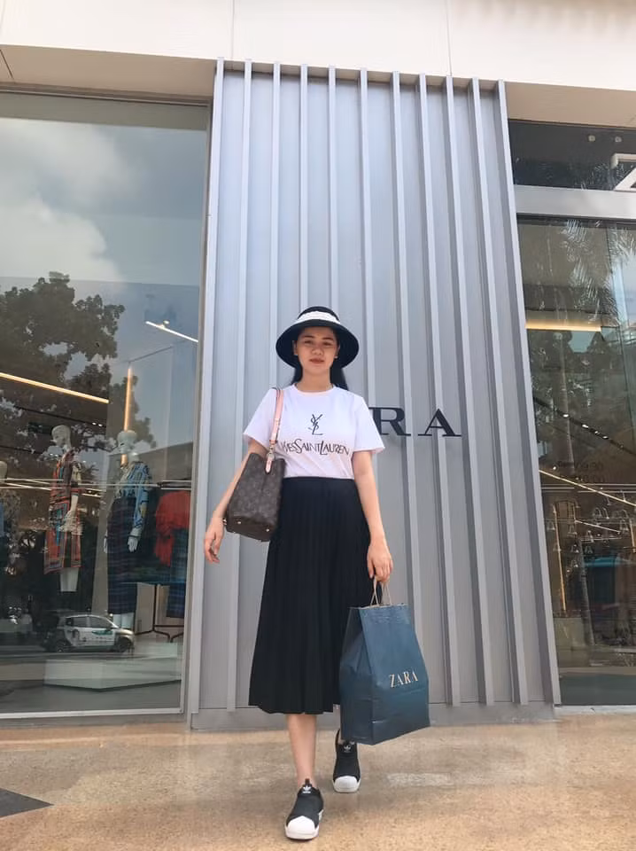Bà mẹ một con phối áo phông trắng với chân váy đen và giầy thể thao giản dị nhưng cũng khá chất.