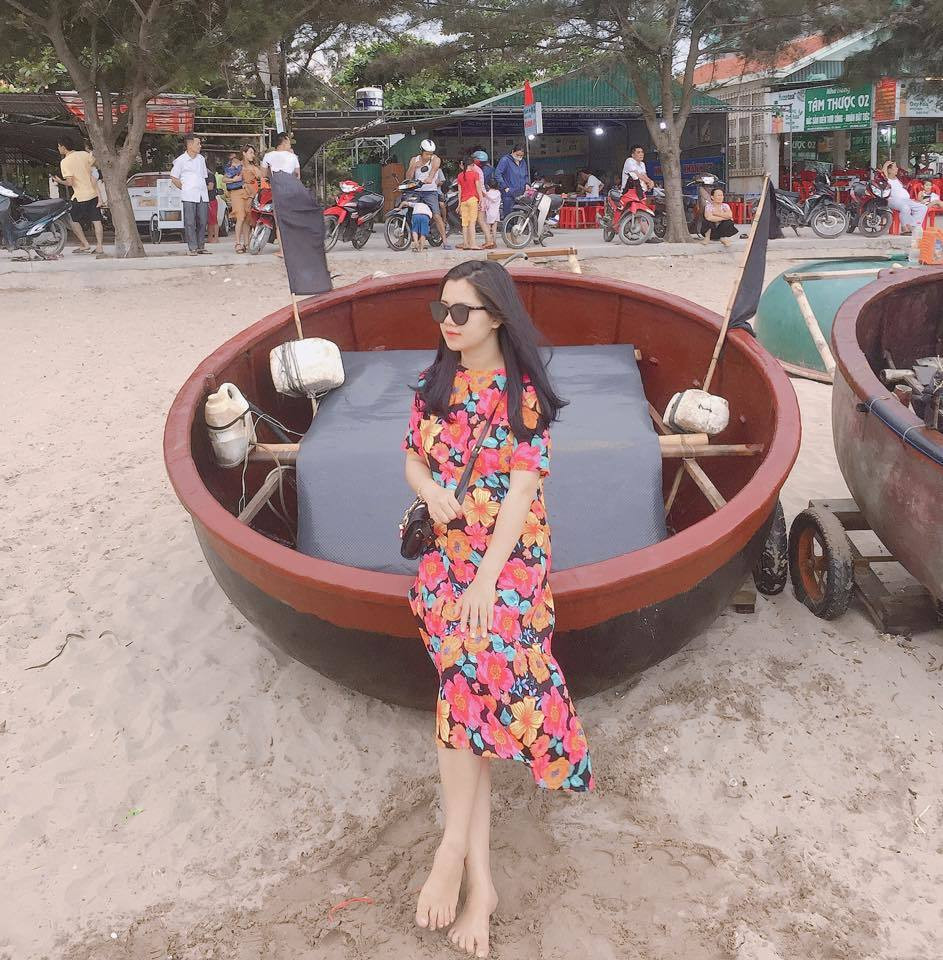 Người đẹp mặc váy hoa nổi bật phối với túi xách và kính đen.