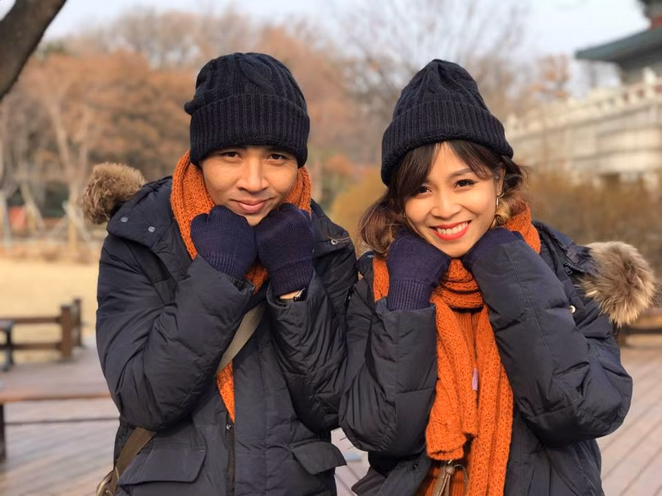 Cặp đôi diện áo phao, mũ len, găng tay và khăn choàng cổ cùng tông.