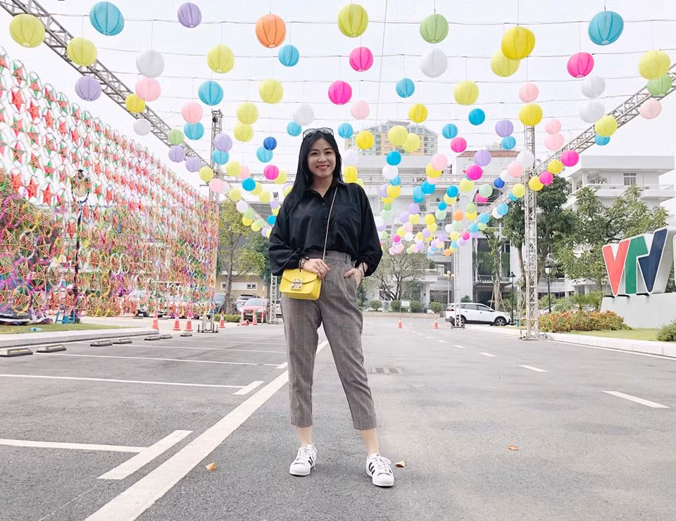 Phong cách thời trang xuống phố của MC Hoàng Linh có phần cá tính khi phối áo sơ mi đen và quần âu, giày thể thao.