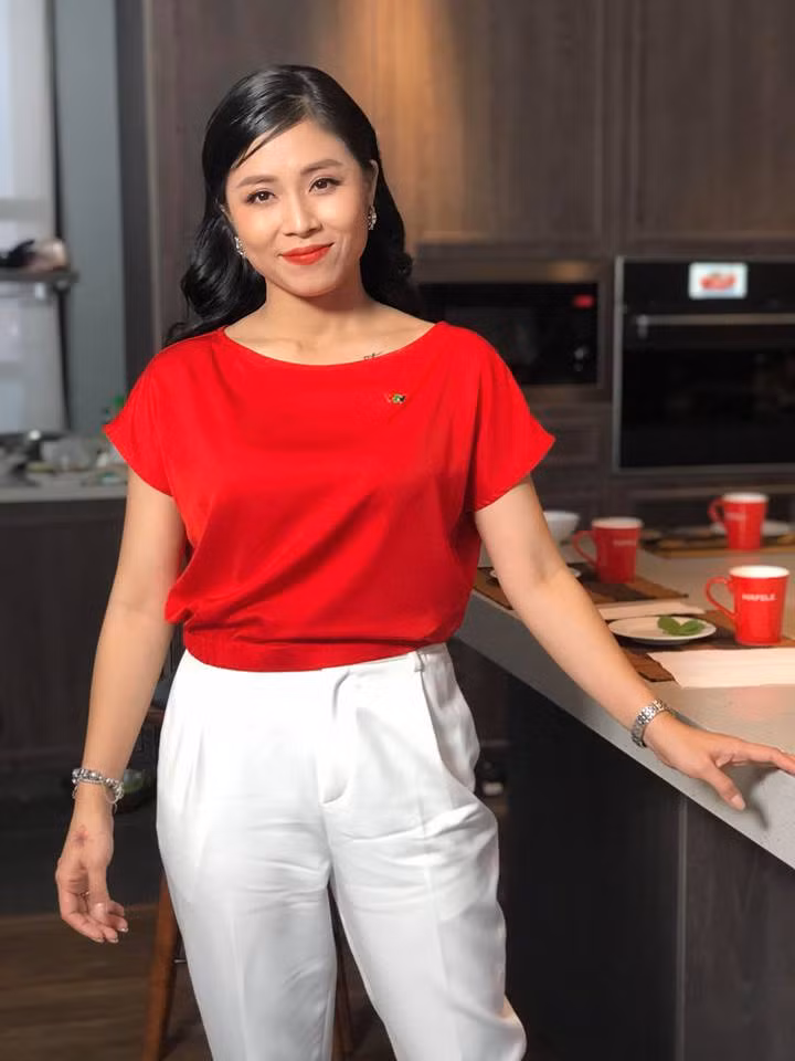 Khi đi làm, cô chọn áo sơ mi đỏ và quần trắng nổi bật.