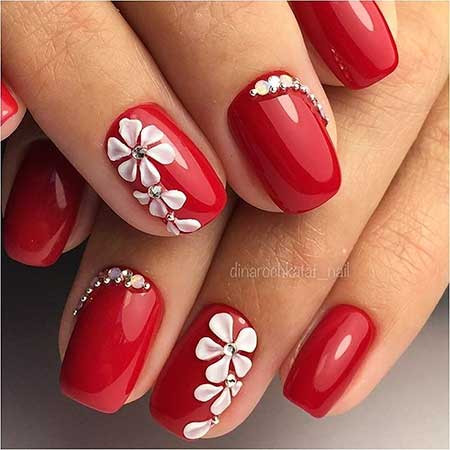 Mẫu nail đỏ đính đá hình bông hoa vừa nổi bật vừa nữ tính.