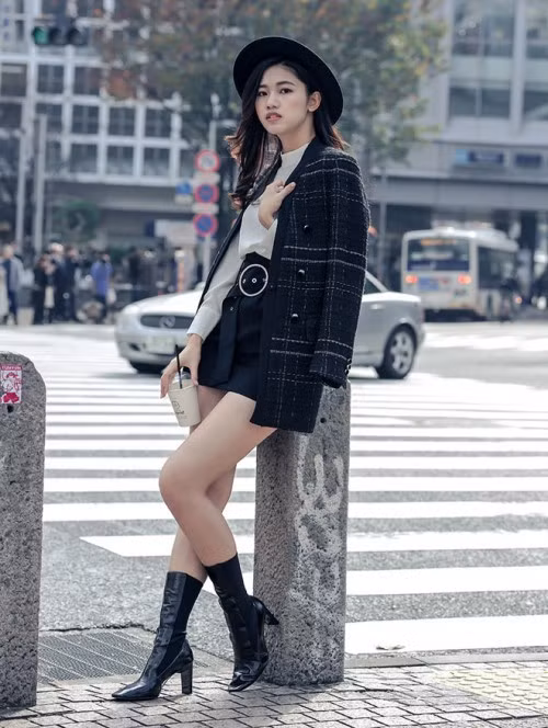 Á hậu Thanh Tú như trở nên thời thượng hơn khi phối áo sơ mi trắng với chân váy ngắn, áo khoác dạ và boot đen cao.