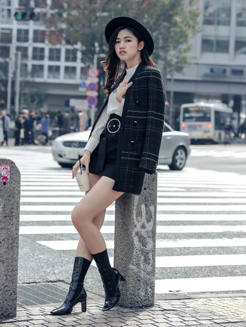 Á hậu Thanh Tú như trở nên thời thượng hơn khi phối áo sơ mi trắng với chân váy ngắn, áo khoác dạ và boot đen cao.