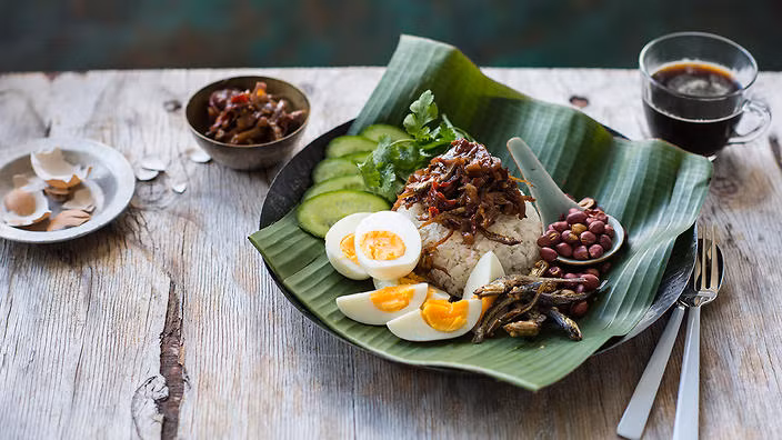 Nasi Lemak: Đây là bữa ăn sáng yêu thích nhất của người Malaysia, thường được gói trong lá chuối. Bên trong là cơm trắng được nấu cùng với sữa hoặc kem dừa nên có mùi rất thơm, ăn kèm với cá cơm chiên, sambal (bột tôm cay), trứng chiên hoặc luộc, đôi khi có thêm chút đậu phộng.