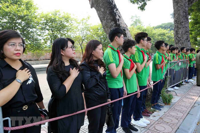 Giáo viên và các em học sinh trường THCS Nguyễn Tri Phương đưa tiễn linh cữu nguyên Tổng Bí thư Đỗ Mười trên phố Hoàng Diệu (Hà Nội). (Ảnh: Thành Đạt/TTXVN)