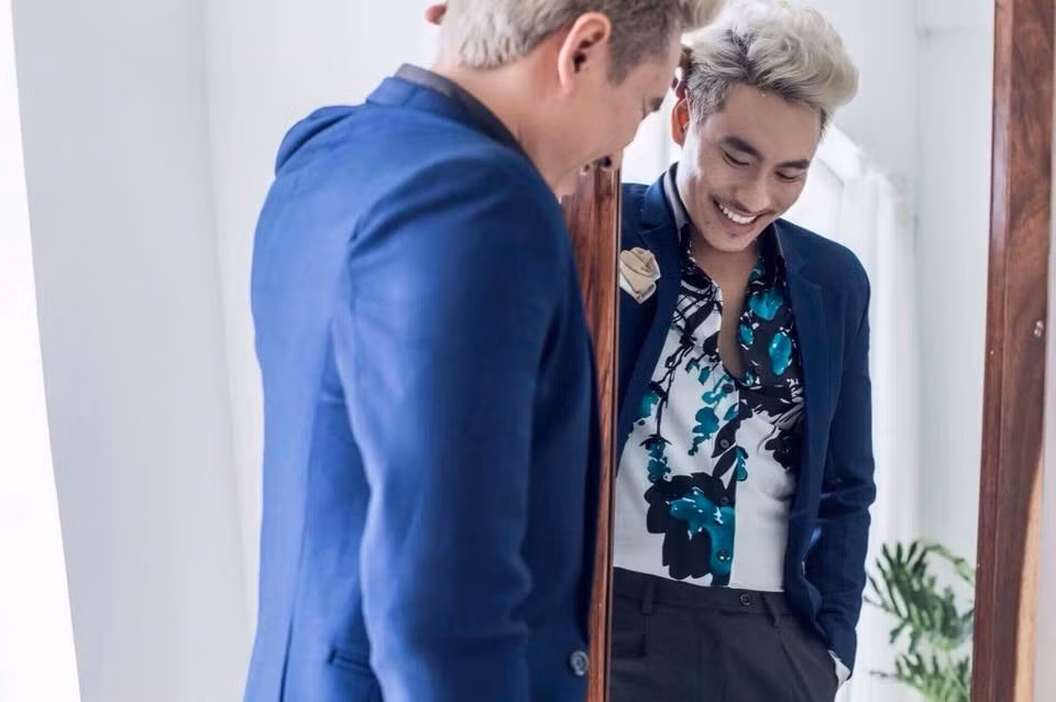 Chiếc áo sơ mi hoa lá bên trong khiến anh bớt đi vẻ nam tính.