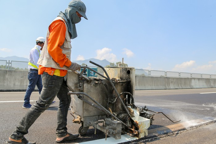 Các công nhân đang gấp rút vẽ vạch sơn ở vị trí mới sửa chữa xong.