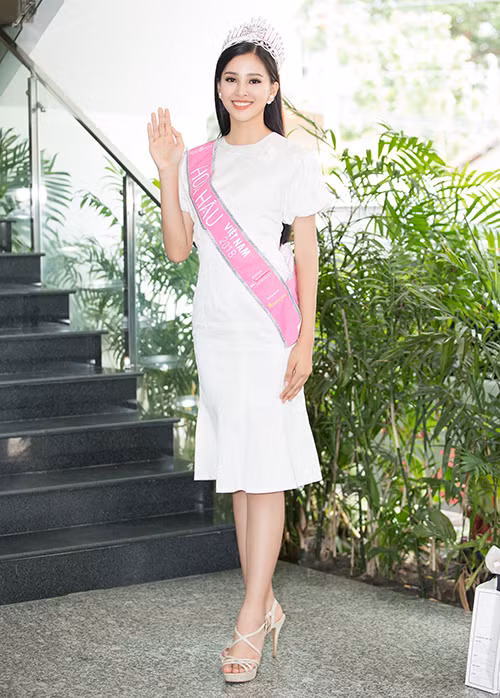 Hoa hậu diện đầm cocktail mang màu trắng tinh khôi, phù hợp với vẻ đẹp trong trẻo tuổi 18.
