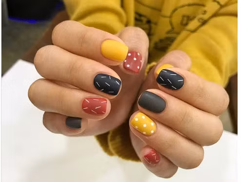 Các màu sắc đan xen trên móng tay, điểm xuyến vài họa tiết.