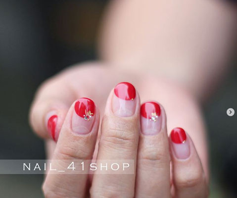 Nail sơn bóng với điểm nhấn là nửa chấm đỏ bên trên.