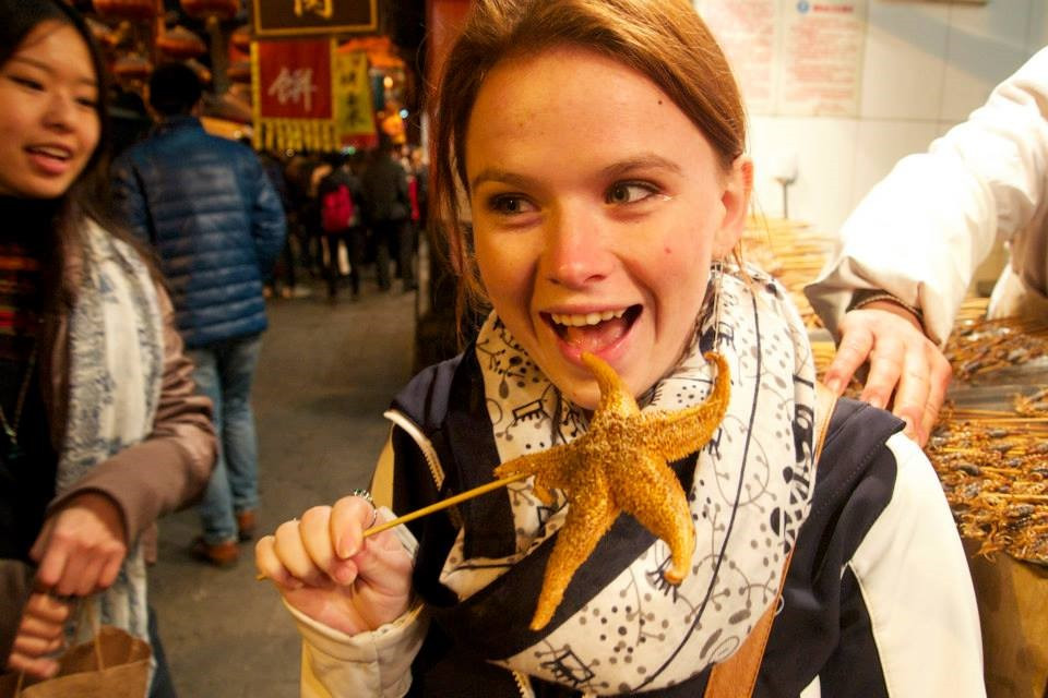 Du khách nếm thử món sao biển trên phố ẩm thực Trung Quốc. Ảnh: Internet.