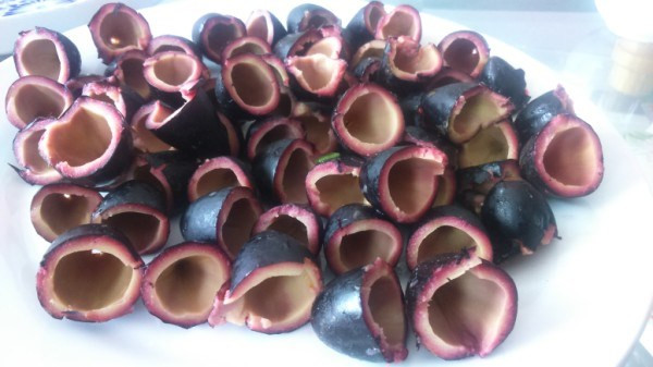 Dùng dao nhỏ sắc hoặc dùng sợi chỉ cuốn quanh cắt đôi quả trám ra, nhẹ nhàng tách bỏ hạt. Nếu muốn để dành ăn dần trong thời gian lâu có thể vài năm thì bỏ trám đã om ngâm trong dầu ăn.