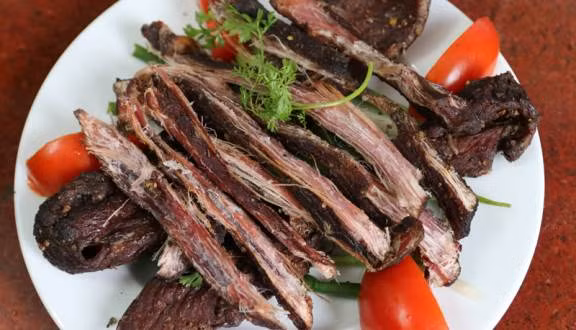 Thịt trâu gác bếp là một những món ăn đặc trưng Điện Biên của đồng bào dân tộc nơi đây. Để làm món thịt trâu ngon, người ta phải lọc cẩn thận hết gân, lọc sạch bạc nhạc, sau đó thái miếng dọc thớ rồi ướp với hỗn hợp gia vị gồm sả, gừng, tỏi, ớt khô băm nhỏ, mắc khén giã nát rồi để khoảng 2-3 tiếng, sau đó lấy que xiên và sấy trên than củi, để xa cho thịt chín từ từ, chín đều. Ảnh: Foody.