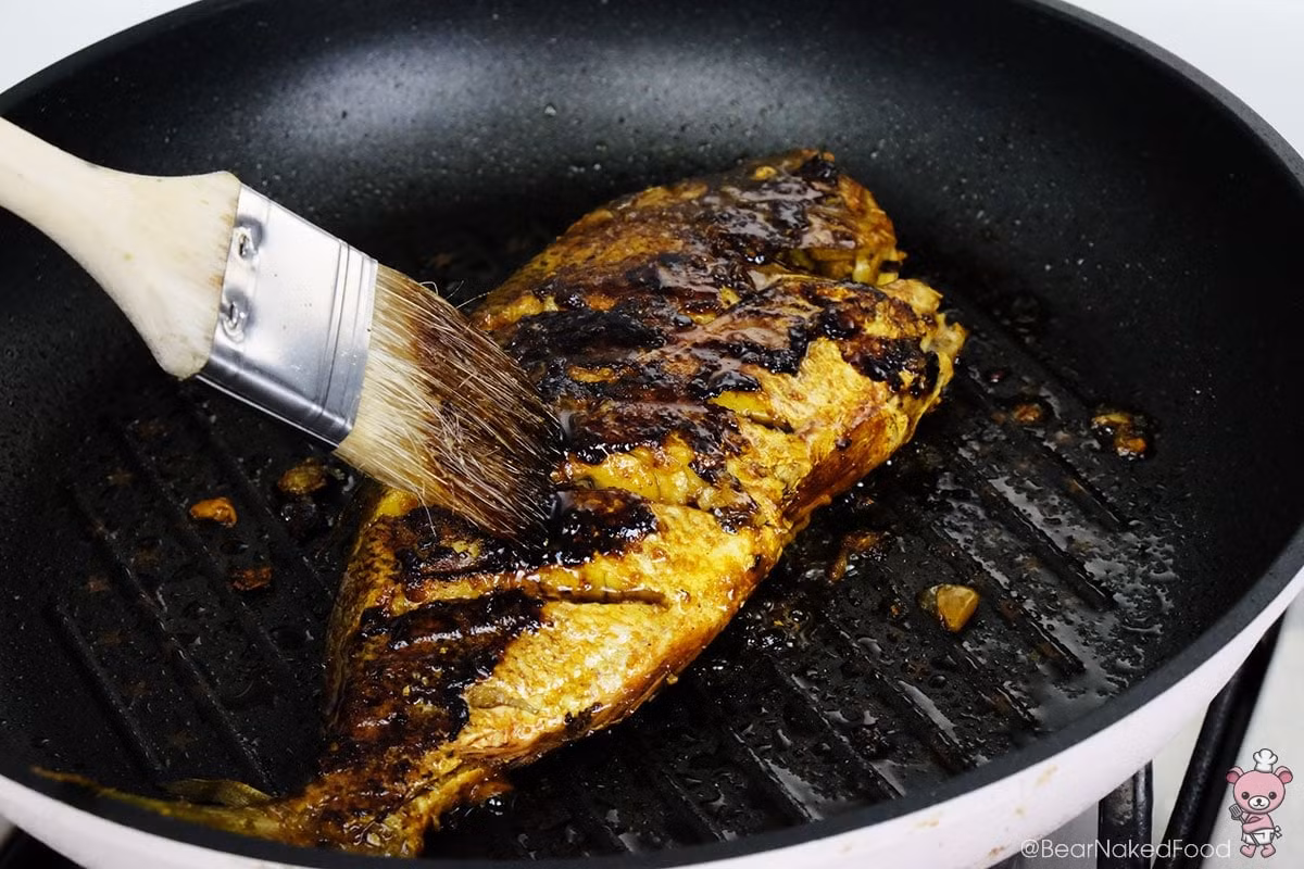 Khi cá gần chín thì phết nước sốt tương ngọt pha sẵn trước đó lên bề mặt cá và tiếp tục nướng cá thêm một chút để cá vàng đều, hấp dẫn hơn.