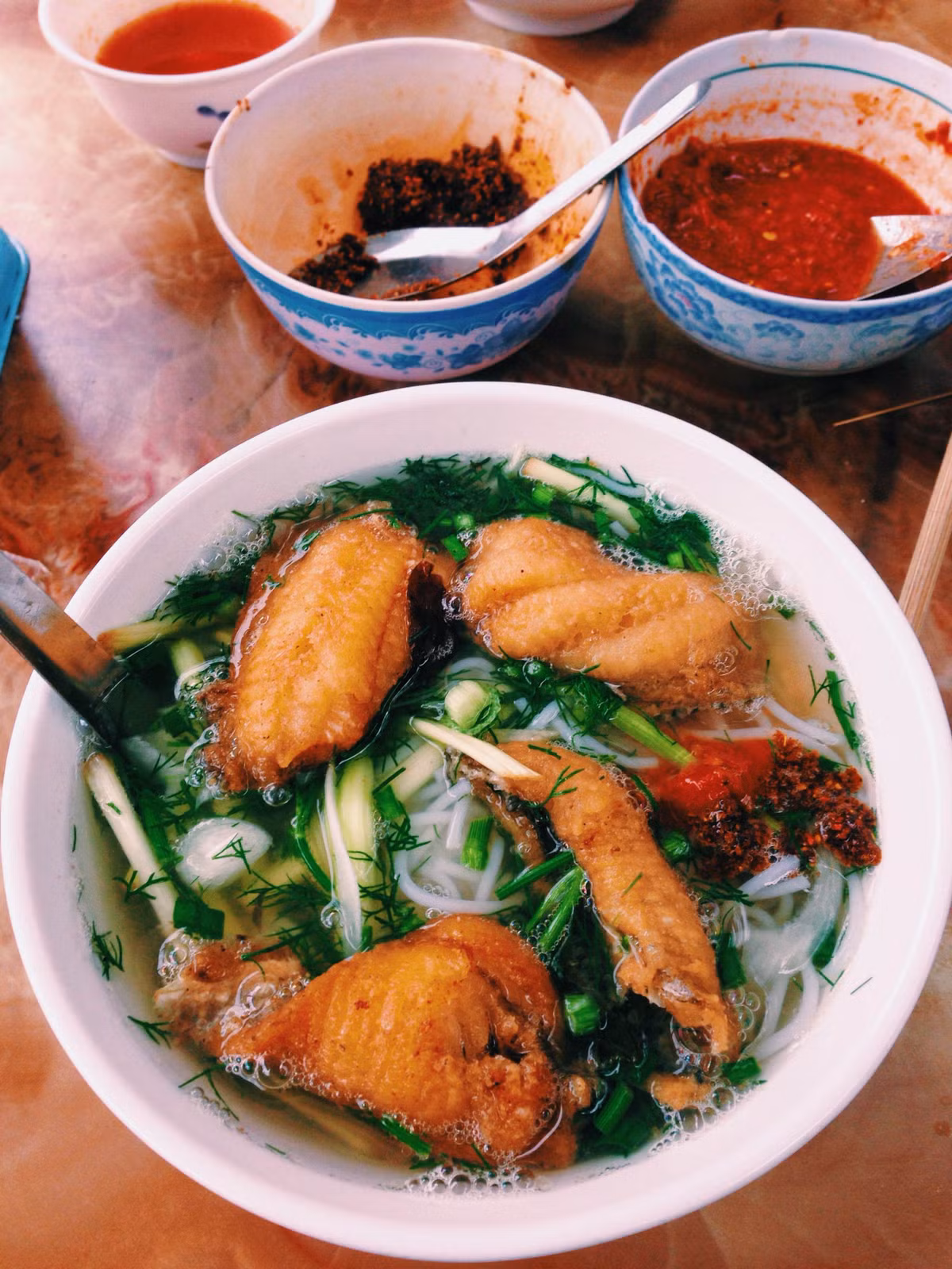 Thêm nhiều công đoạn chế biến kỳ công cùng những bí quyết gia truyền mới có được thành quả tô bún cá rô đồng hài hòa hương vị, mãn nhãn về màu sắc. Sắc xanh của rau thì là, dọc mùng, rau cải… hòa quyện với màu vàng rộm của miếng cá chiên cùng sợi bún đượm vị ngon ngọt. Ảnh: VOV. 