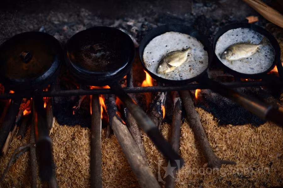 Muốn ăn bánh khoái cá kình thì phải về chợ làng Chuồn. Ngôi chợ nhỏ nằm bình yên bên cạnh đầm phá Tam Giang. Những quầy bánh nhỏ nhắn ngồi trong những góc chợ với hàng khuôn bánh đỏ rực lửa trước mặt. Ảnh: Lao động.