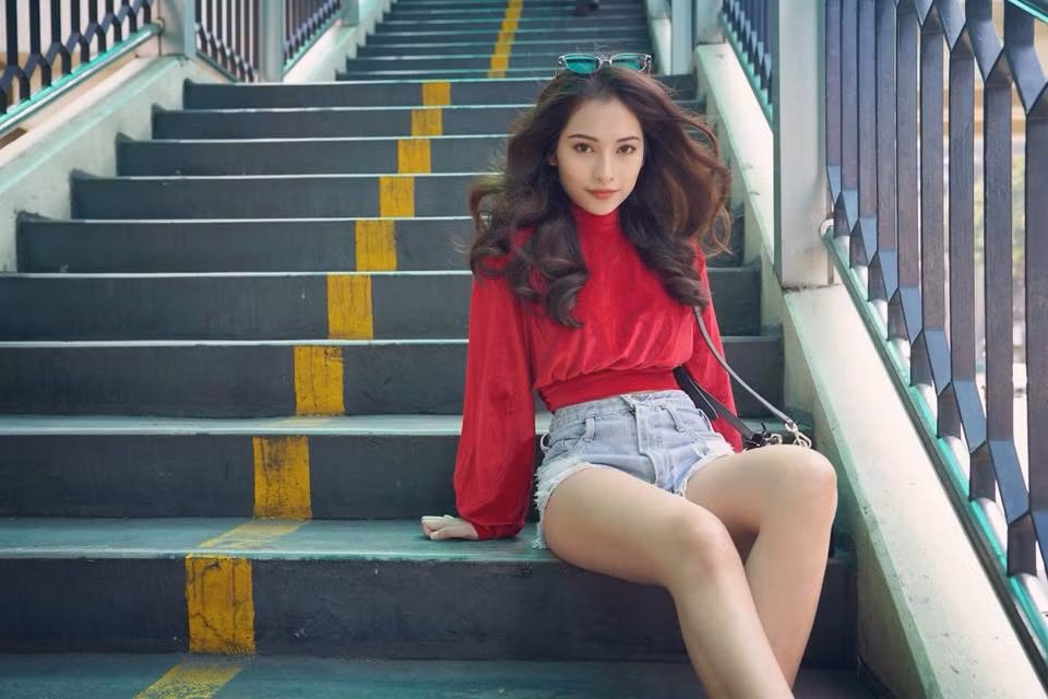 Áo thun đỏ và quần short bò rách đem đến cho cô nàng 24 tuổi nét cá tính, năng động.