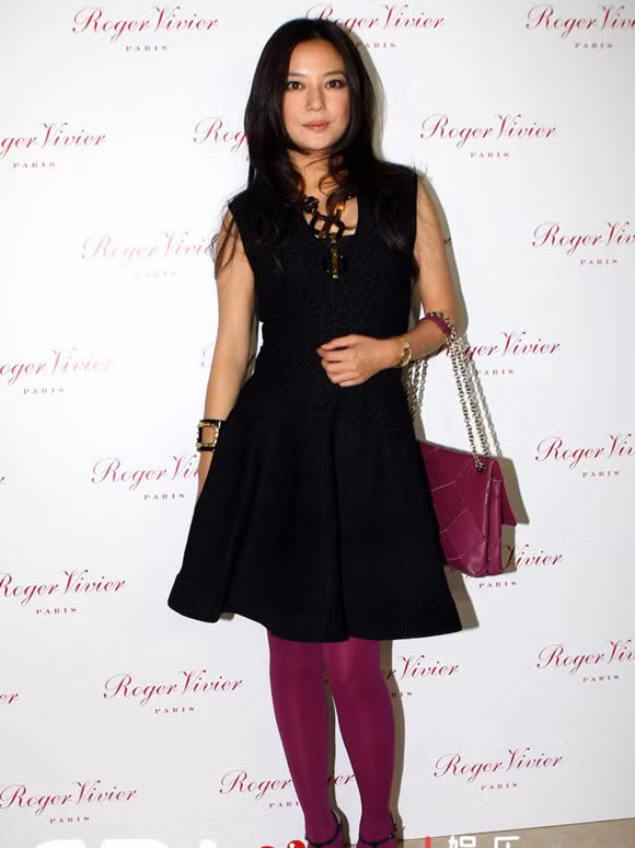 “Én nhỏ” lại tự biến mình thành thảm họa thời trang khi diện bộ đầm màu đen và đi tất chân hồng đậm.