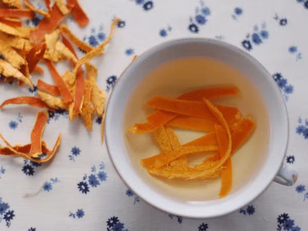 Trà vỏ cam rất giàu pectin, hỗ trợ sự phát triển của vi khuẩn có lợi hoặc probiotic trong ruột, do đó duy trì một hệ thống đường ruột khỏe mạnh. Cắt vỏ cam và thêm vào một cốc nước sôi. Đun sôi trong 10 phút. Sau đó, chắt nước uống. Ảnh: Boldsky. 