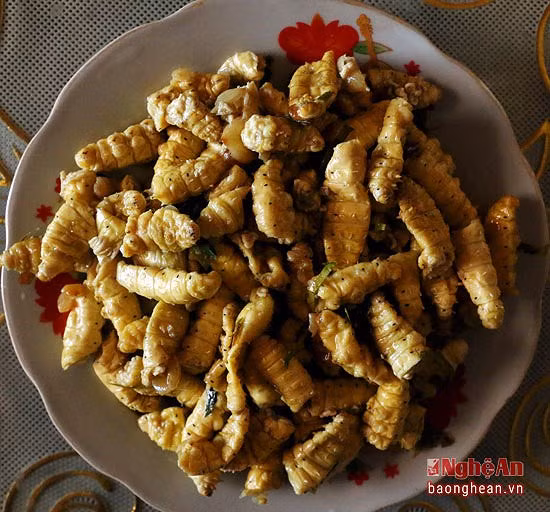 Sau đó, đổ tằm đã rang vào, trộn đều, cho thêm chút mỡ nước đảo cho cả tằm và thịt cùng khô, tỏa mùi thơm thì bắc ra. Sau đó rắc một ít lá chanh thái chỉ vào chảo tằm rang vừa bắc xuống. Số lá chanh còn lại được rắc lên trên đĩa tằm rang cho đẹp mắt.