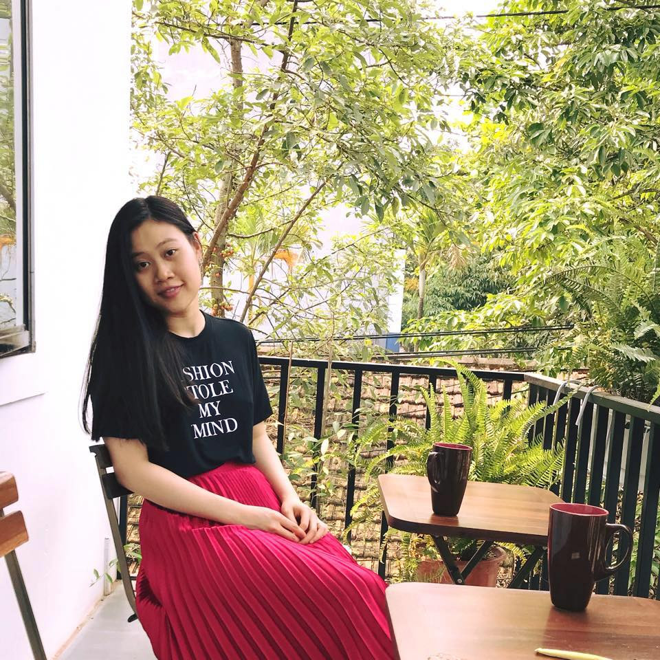 Cô phối áo phông đen với váy xếp ly đỏ nữ tính.