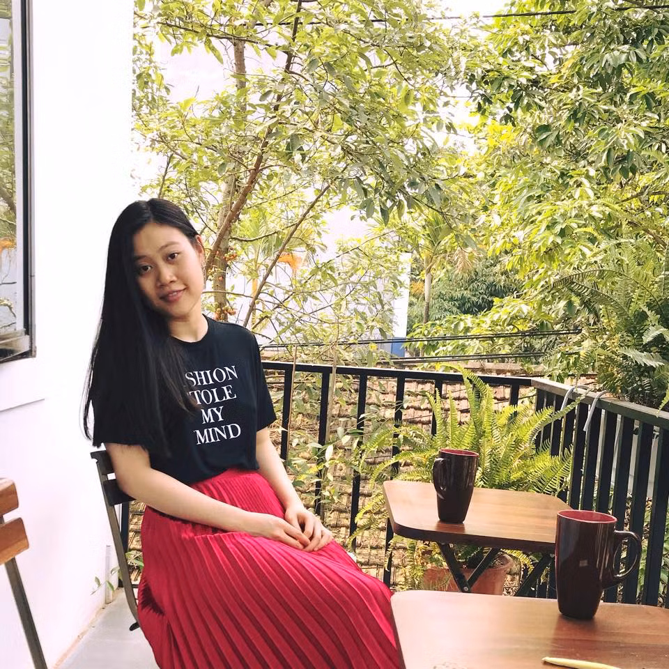 Cô phối áo phông đen với váy xếp ly đỏ nữ tính.