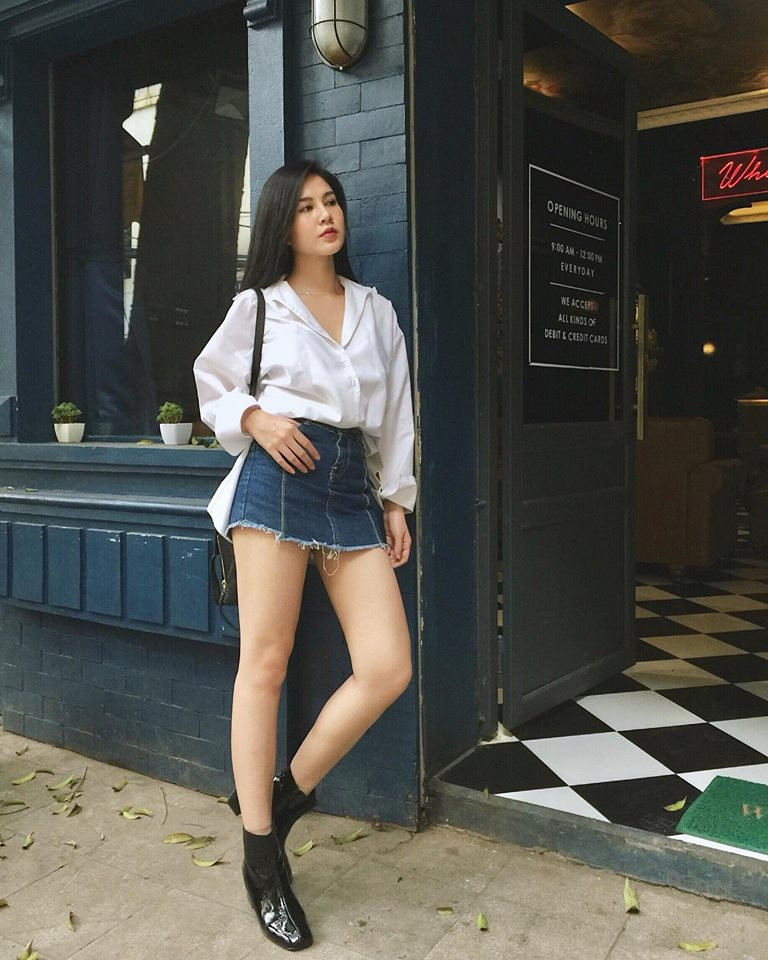 Áo sơ mi trắng và váy jean ngắn khoe đôi chân dài trắng nõn.